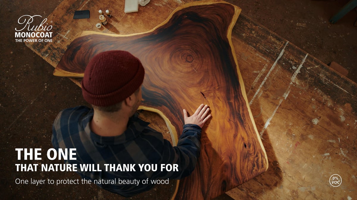 Person wearing burgundy beanie touching wooden surface with natural grain patterns, demonstrating wood protection product application